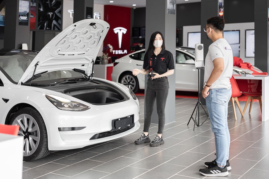 An image showing a Tesla vehicle being serviced by a technician, representing the importance of maintaining a Tesla for optimal performance and longevity.