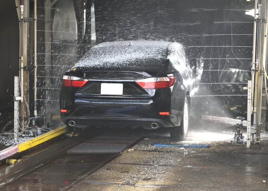 A person cleaning a Tesla car to maintain its shine and prevent damage