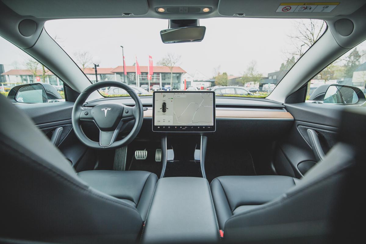 A person checking the software updates on a Tesla car's touchscreen display.