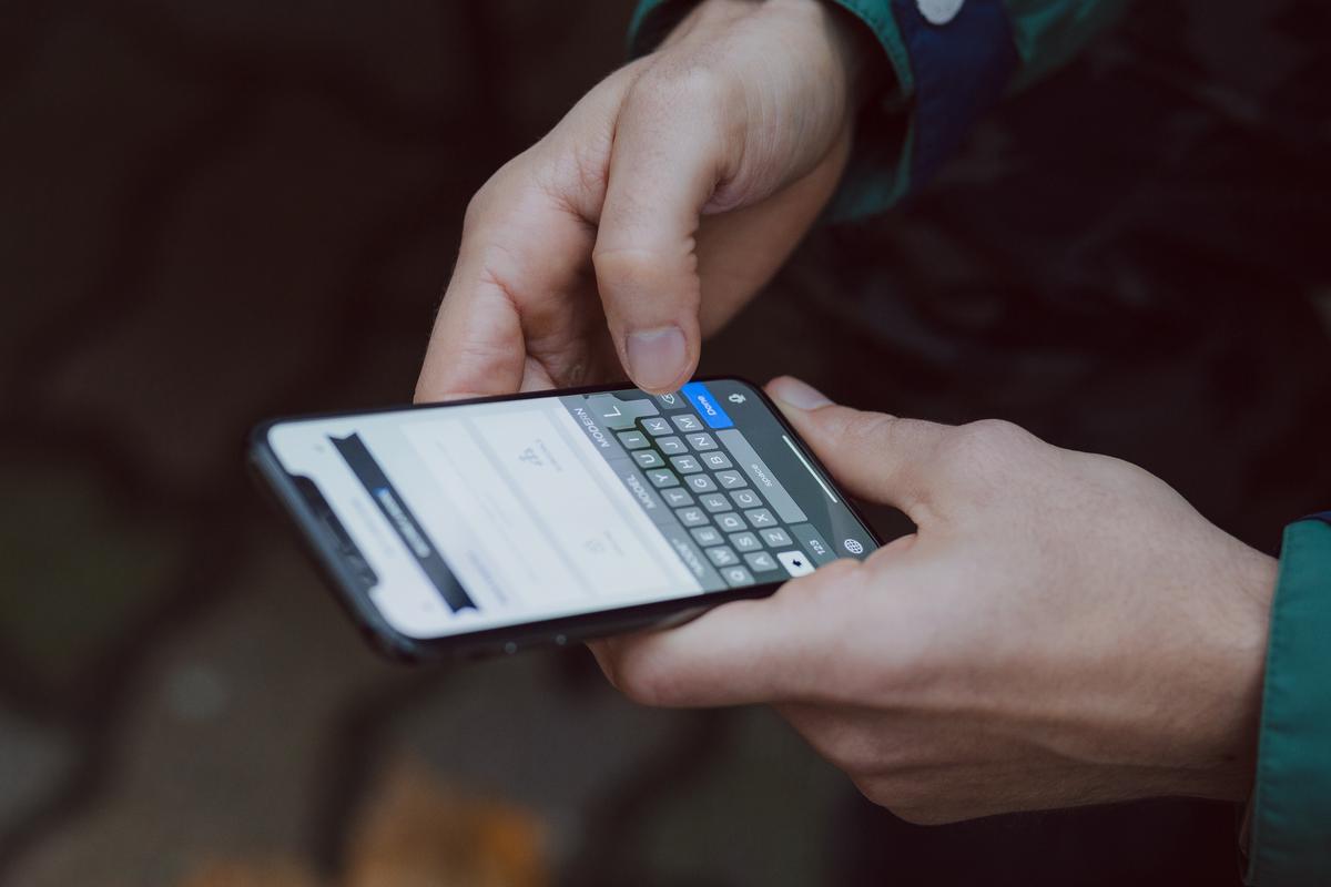 A person holding a smartphone displaying a Tesla software update notification.