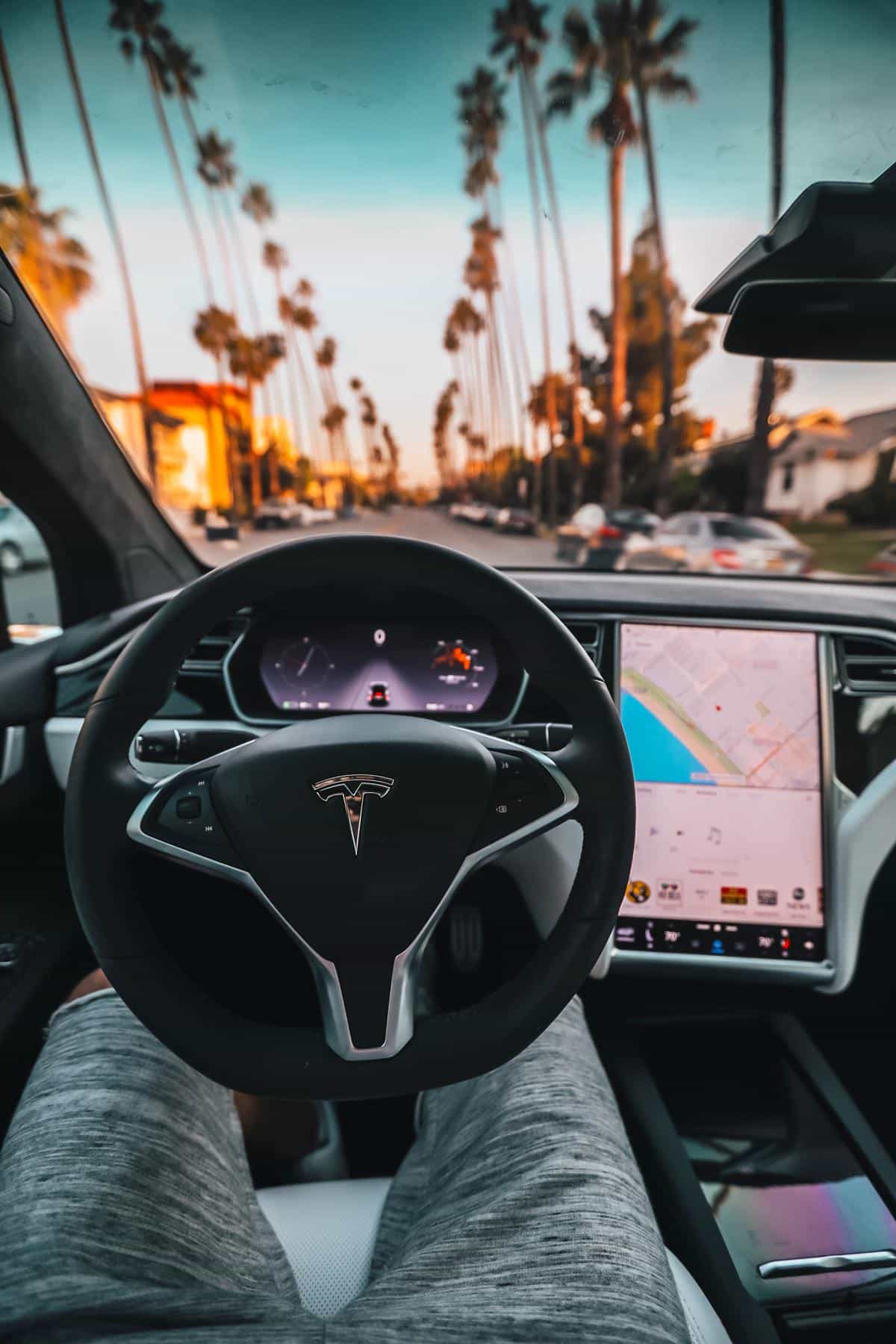 A person interacting with a Tesla touchscreen in a car