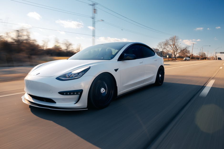 A Tesla car driving on a snowy road during winter